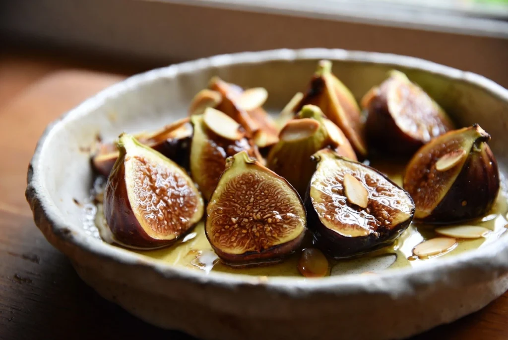 Figues fraîches rôties au miel et amandes dorées dans un plat rustique